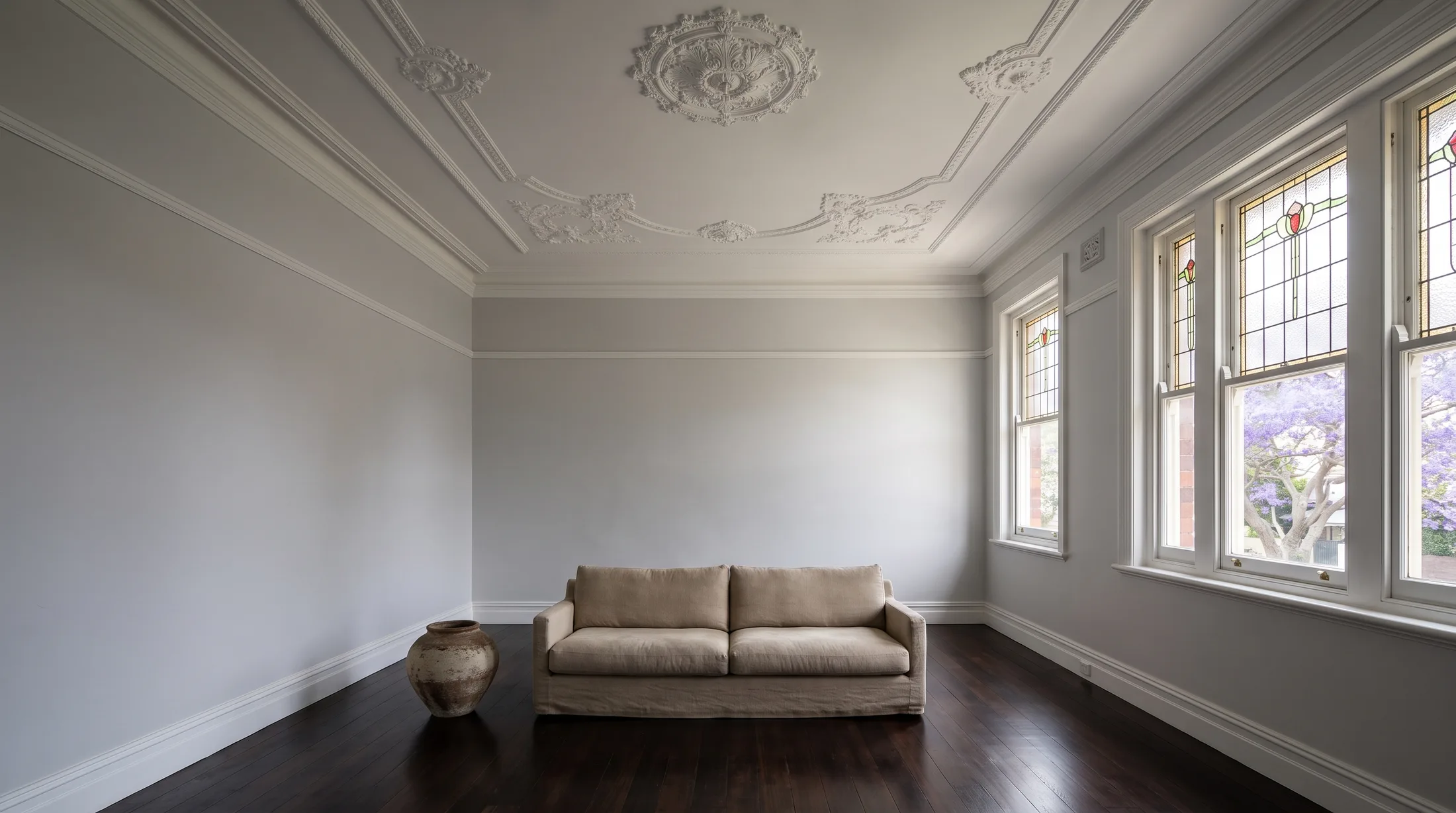 A freshly painted living room in an older Sydney home, cornices and picture rails picked out in white